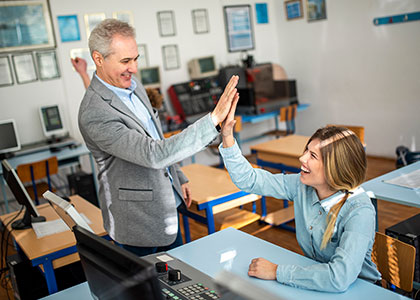 Middle-aged male teacher high-fiving his student